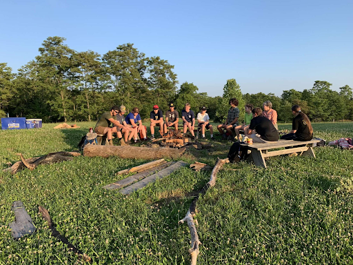 Clayton and others relaxing around the campfire.